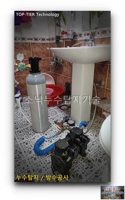 대구 북구 복현동 누수, 세면대 옆 욕실 바닥에 놓은 압력계와 검은색 컴프레서, 은색 가스 용기