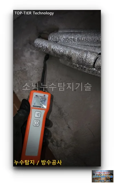 대구 북구 복현동 누수, 은박 보온재 배관이 바닥으로 들어가는 자리에 검출봉을 댄 주황색 가스 검출기