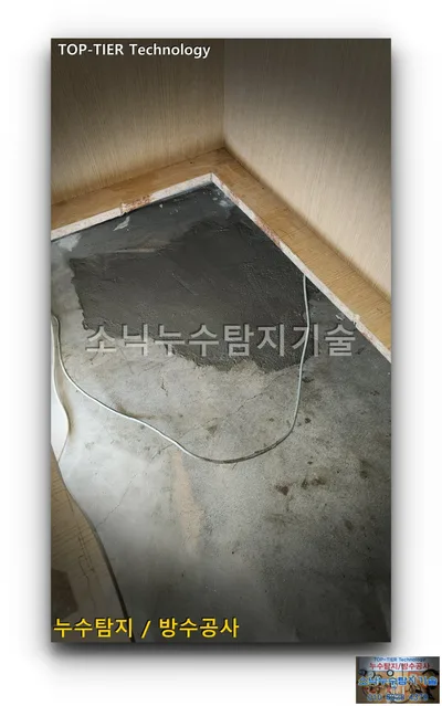 대구 달서구 대곡동 누수, 하부장 안쪽 콘크리트 바닥에 짙은 회색 시멘트로 미장한 자리와 흰 전선