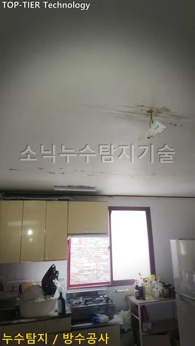 대구 달서구 호산동 누수, 어두운 물 얼룩이 번진 흰 천장과 그 아래 노란 주방 수납장, 자줏빛 창틀 창문