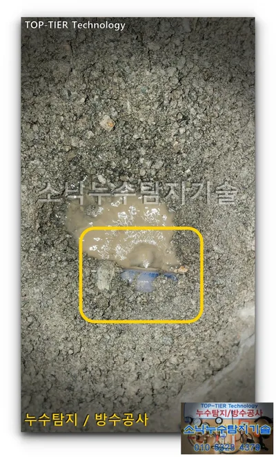경산 사동 굴착한 흙과 자갈 가운데 드러난 파란빛 관을 노란 사각으로 표시한 사진