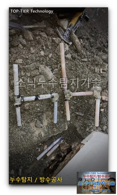 경산 사동 흙 위에 드러난 흰빛 배관과 살구빛으로 변색된 배관의 잘린 단면