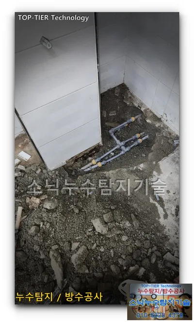 경산 사동 식당 안쪽 구석 파낸 바닥에 회색 배관 두 줄을 황동빛 이음쇠로 이은 모습