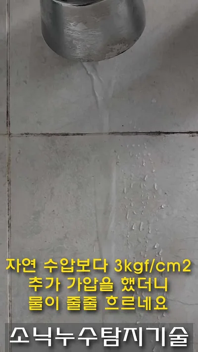 욕실 벽 크롬 수전 소켓 아래로 물줄기가 타일을 타고 흘러내리는 모습