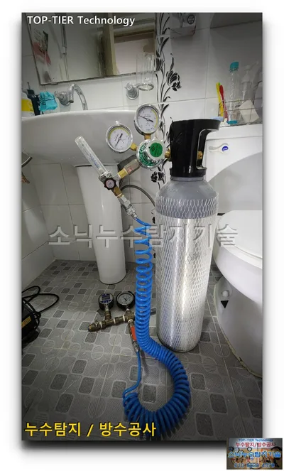 원룸 세대 욕실 바닥에 세운 가스통과 압력계, 파란 호스로 이은 대구 수성구 누수 테스트 장비