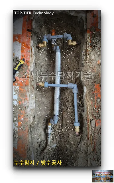 대구 수성구 신세계타운 누수, 굴착 홈의 회색 배관과 엘보, 황동 부속 연결부와 가운데를 지나는 은색 보온재 배관