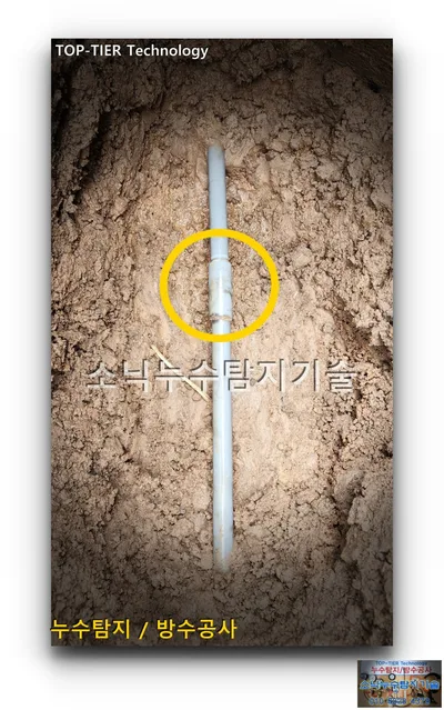 넓게 파낸 흙 속 회색 PVC 수도배관에 노란 원으로 짚은 영양군 주실마을 누수 연결부
